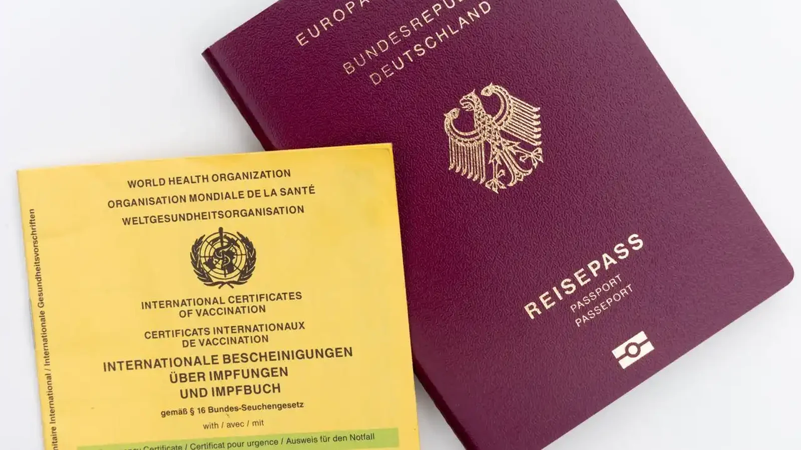 The yellow World Health Organization International Certificate of Vaccination, or ICVP, lying beside a passport ready for travel